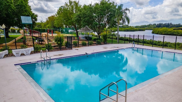 view of pool featuring a playground and a water view