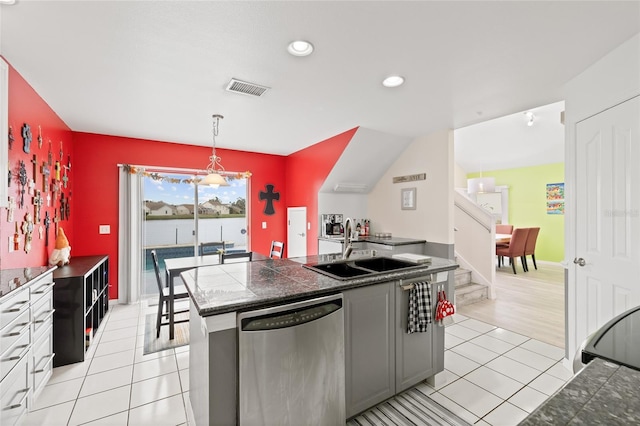 kitchen featuring a sink, tile counters, dishwasher, light tile patterned floors, and visible vents