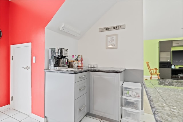 kitchen with baseboards, lofted ceiling, and light tile patterned floors
