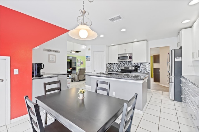 dining space with light tile patterned flooring, visible vents, baseboards, ceiling fan, and recessed lighting
