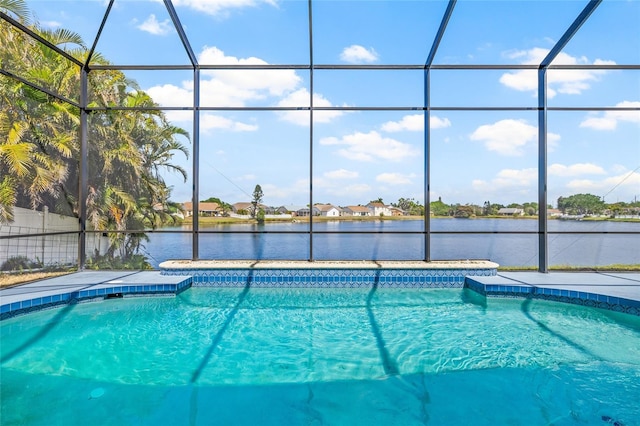 pool featuring a lanai, a water view, and a patio area