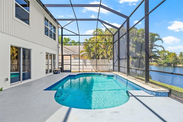 outdoor pool featuring glass enclosure, a water view, and a patio area