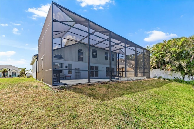 back of house featuring a lawn, fence, a patio, and a lanai