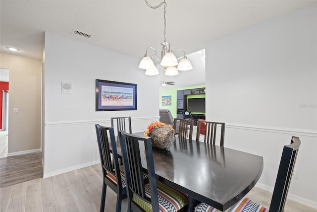 dining room with baseboards, visible vents, an inviting chandelier, and light wood finished floors
