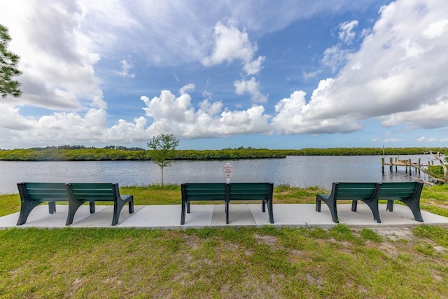 surrounding community featuring a lawn and a water view