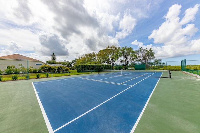 view of tennis court featuring community basketball court and fence