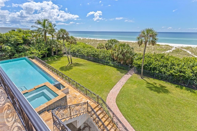 view of swimming pool featuring a yard, a beach view, an in ground hot tub, a water view, and a patio