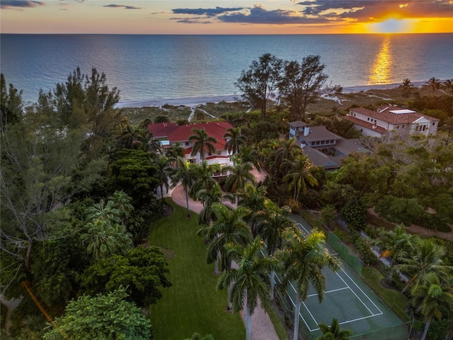 aerial view at dusk featuring a water view