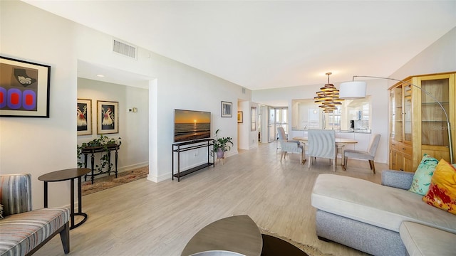 living room with light wood-type flooring and lofted ceiling