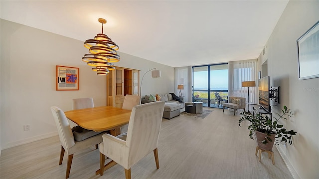 dining area with expansive windows, light hardwood / wood-style floors, and a chandelier