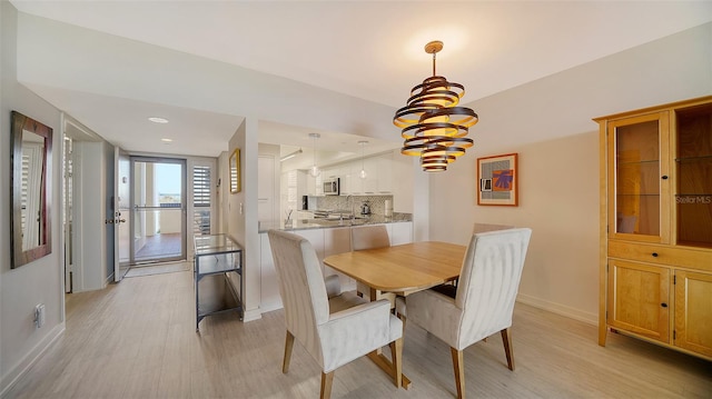 dining room featuring a notable chandelier and light hardwood / wood-style flooring