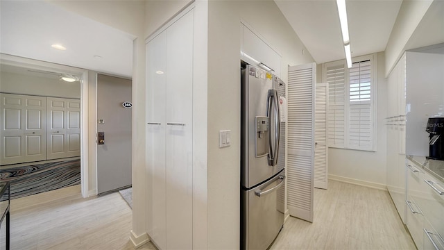 kitchen featuring white cabinets, stainless steel refrigerator with ice dispenser, and light hardwood / wood-style floors