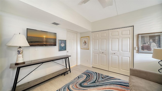 bedroom with a closet, light wood-type flooring, and ceiling fan