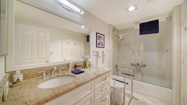 bathroom featuring bath / shower combo with glass door, vanity, and hardwood / wood-style flooring