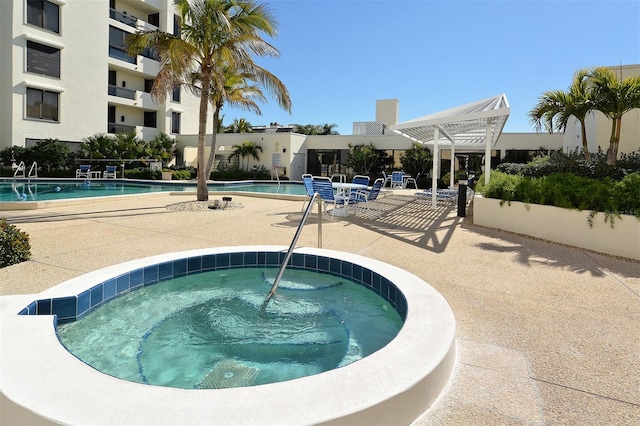 view of swimming pool featuring a community hot tub and a patio area