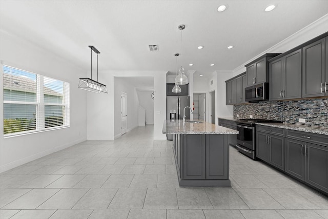 kitchen featuring a center island with sink, ornamental molding, decorative light fixtures, and appliances with stainless steel finishes