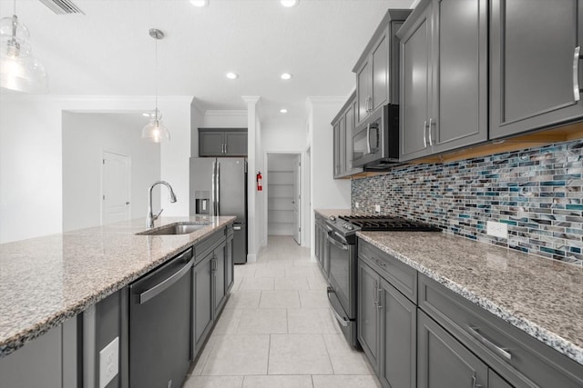 kitchen featuring light stone countertops, appliances with stainless steel finishes, gray cabinetry, sink, and hanging light fixtures