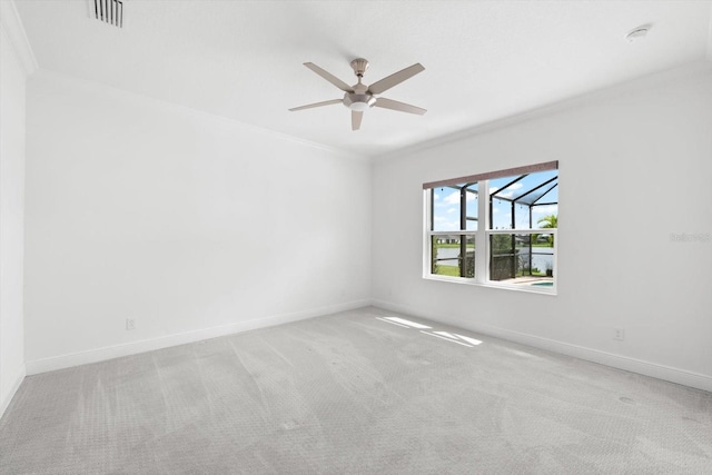 empty room with crown molding, ceiling fan, and light carpet