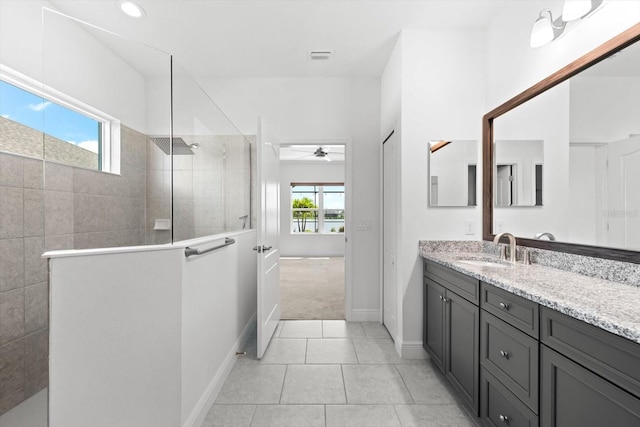 bathroom with vanity, a wealth of natural light, ceiling fan, and tiled shower