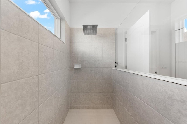 bathroom with a wealth of natural light and tiled shower