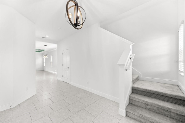 stairs with tile patterned floors and a chandelier