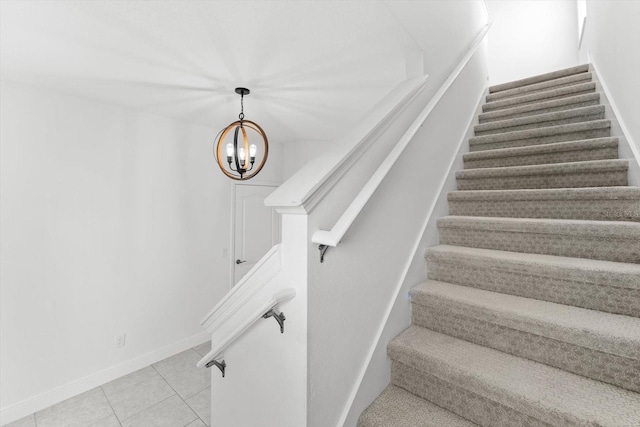 stairway with an inviting chandelier and tile patterned floors