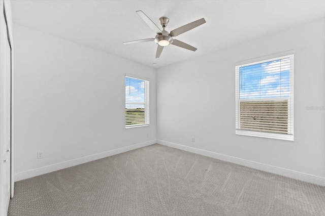 empty room with ceiling fan and light colored carpet