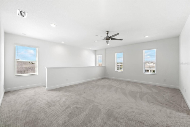 carpeted empty room with ceiling fan and a healthy amount of sunlight