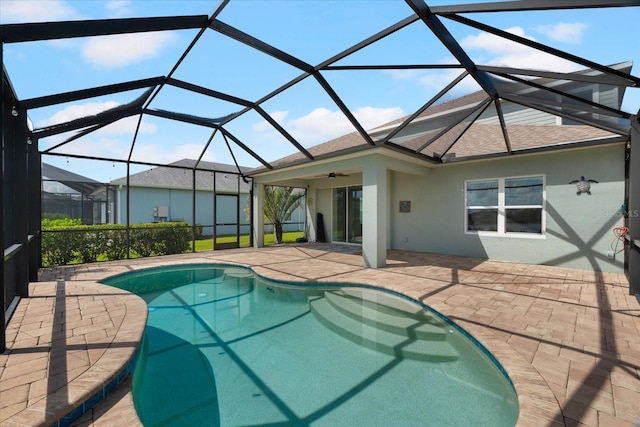 view of swimming pool with glass enclosure, ceiling fan, and a patio area