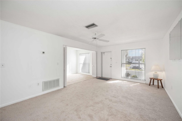 spare room featuring light colored carpet and ceiling fan