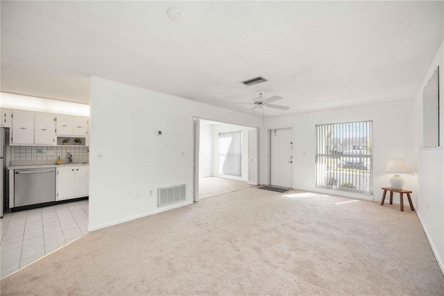 unfurnished living room featuring light colored carpet and ceiling fan