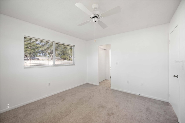 carpeted spare room with ceiling fan