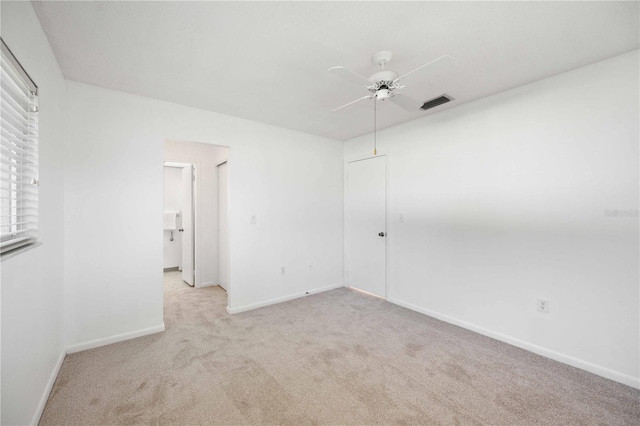 empty room featuring light colored carpet and ceiling fan