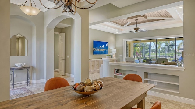 dining space with ceiling fan with notable chandelier, crown molding, and a tray ceiling