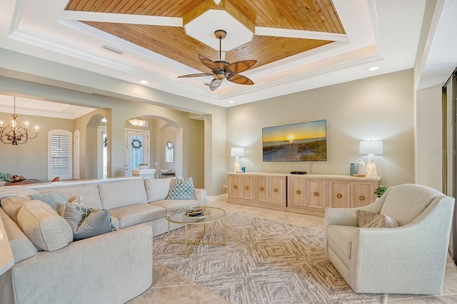 tiled living room featuring ceiling fan with notable chandelier, wood ceiling, crown molding, and a tray ceiling