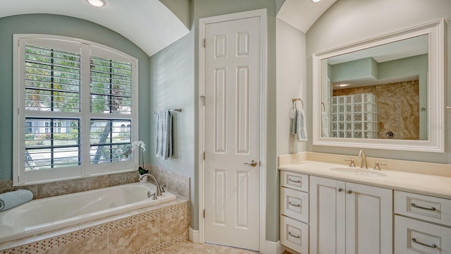 bathroom with a relaxing tiled tub, vanity, tile patterned floors, and vaulted ceiling