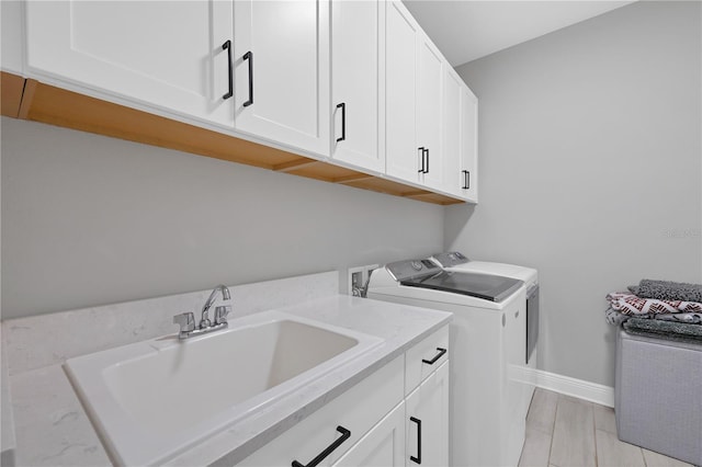 laundry room with washer and dryer, sink, and cabinets