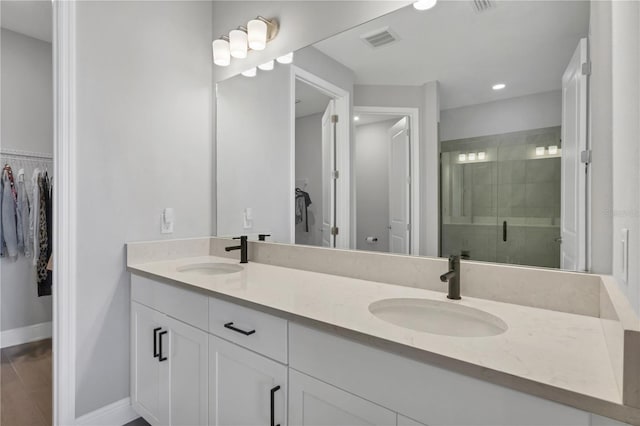 bathroom with vanity and a shower with door