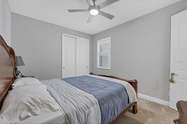 bedroom featuring a closet, light colored carpet, and ceiling fan