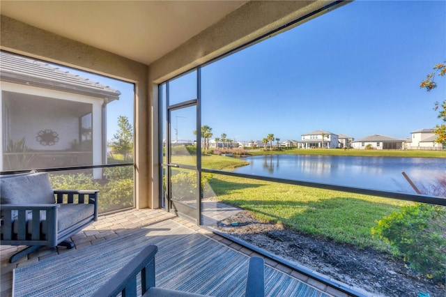 sunroom featuring a water view