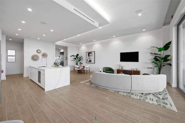 living room with light hardwood / wood-style floors and sink