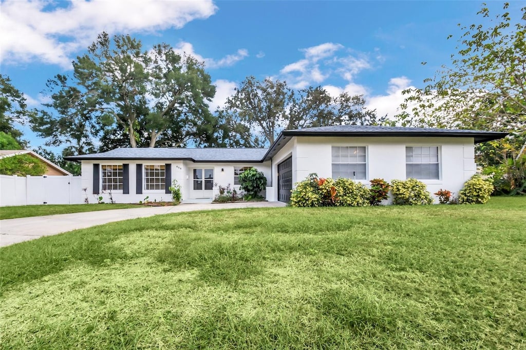 ranch-style house with a garage and a front lawn