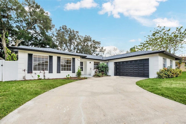 ranch-style home featuring a garage and a front lawn