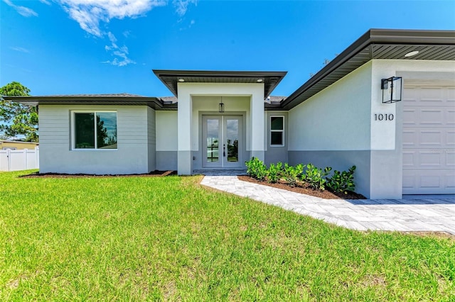 property entrance with a garage, a yard, and french doors