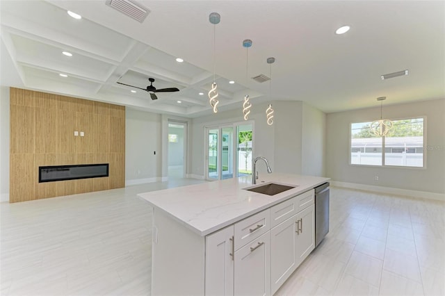 kitchen with white cabinetry, coffered ceiling, sink, and a healthy amount of sunlight