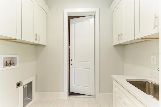 clothes washing area featuring cabinets, hookup for an electric dryer, sink, and washer hookup