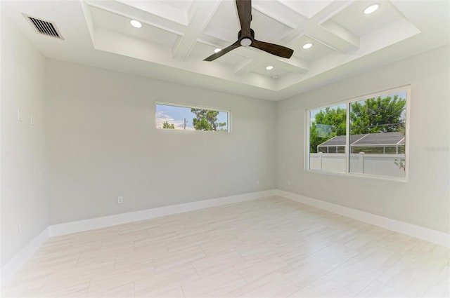 spare room with coffered ceiling, ceiling fan, plenty of natural light, and beamed ceiling