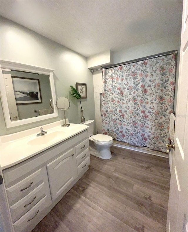 bathroom featuring hardwood / wood-style floors, vanity, a textured ceiling, and toilet