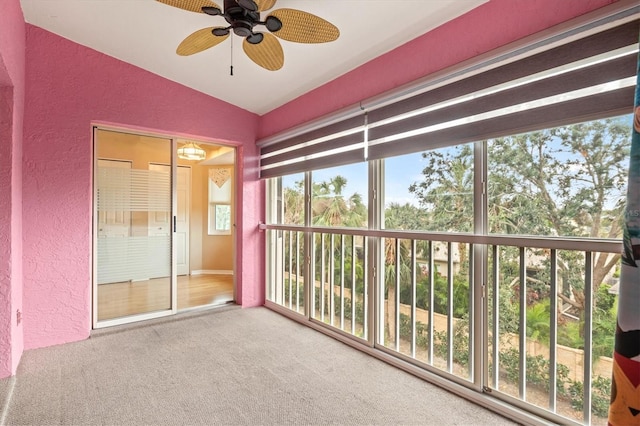 unfurnished sunroom featuring ceiling fan, plenty of natural light, and vaulted ceiling