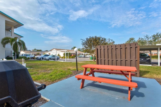 view of home's community with a carport and a yard